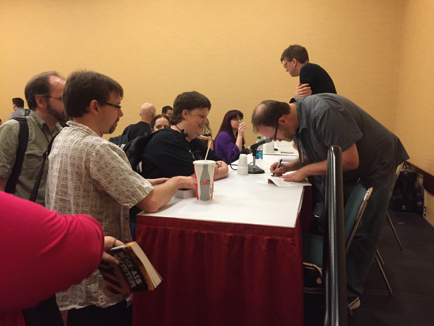 Chuck Wendig signs books for a fan after a panel