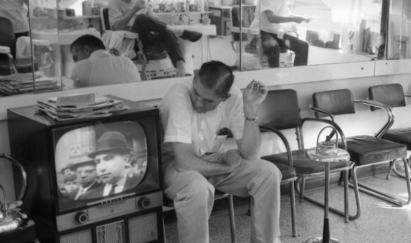 The final episode of the first series of The Secret Life of Machines examines the development of television, much like the set this man is watching at a barber shop in Tallahassee, FL, USA. (Collection of the State Library and Archives of Florida - no known copyright restrictions).