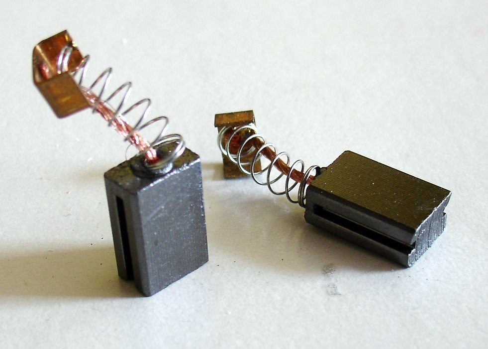 A picture of two carbon brushes, including springs, that are used with electric motors