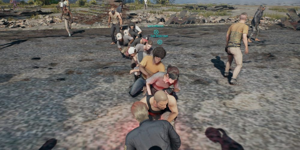 A line of players waiting in the pre-game area for 'PLAYERUNKNOWN'S BATTLEGROUNDS', crouched down and leaning left or right.