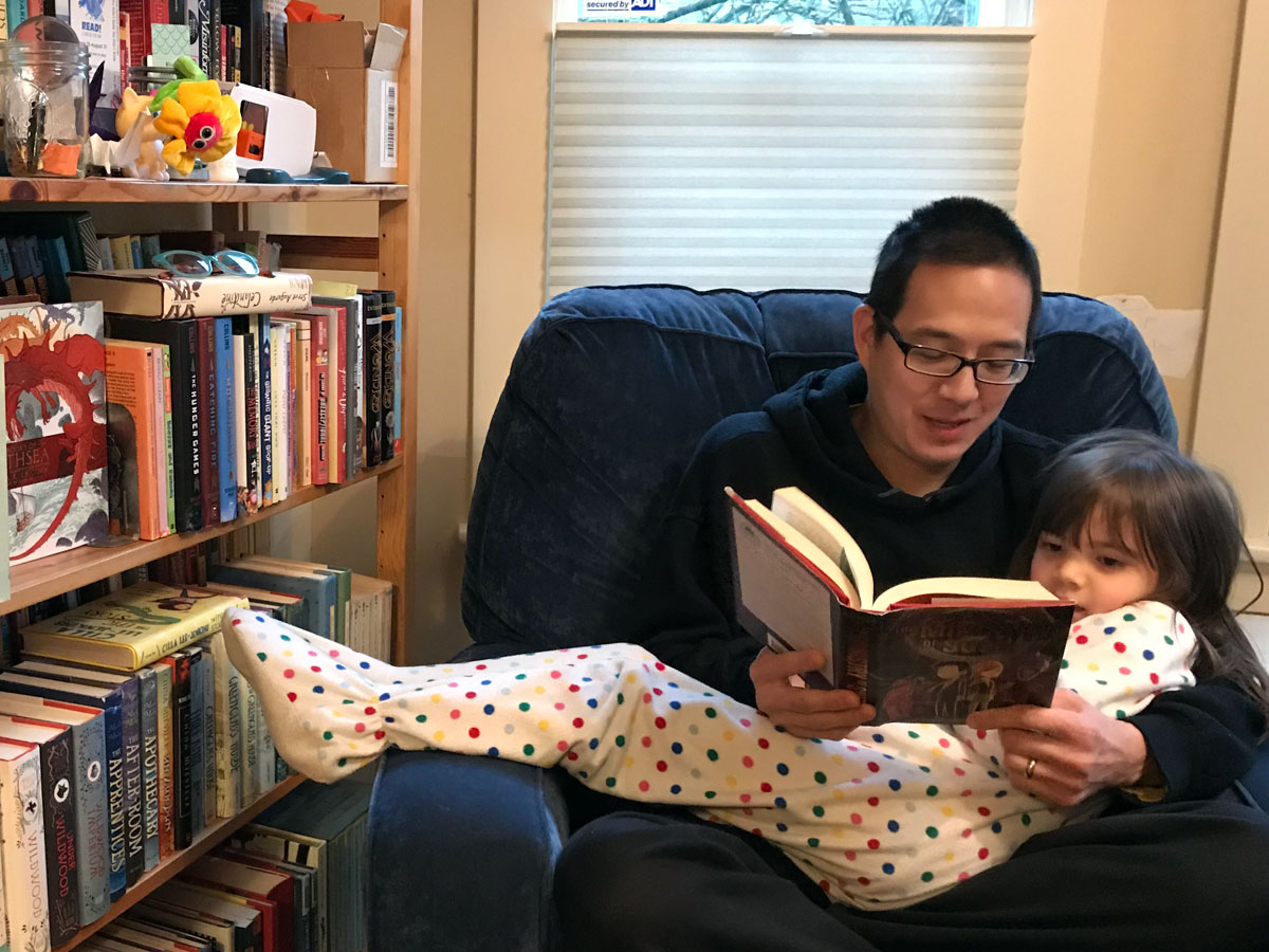 Jonathan reading a book to his daughter