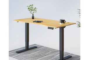 An adjustable-height sit or stand desk with a back frame and a brown surface.